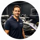 Sy Scheelbeek naast een Grand Prix raceauto in een technische werkplaats